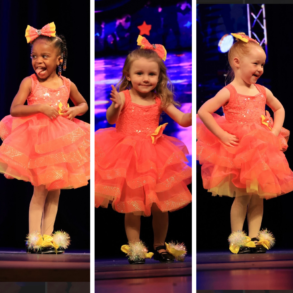 Three young dancers in sparkling coral costumes performing on stage